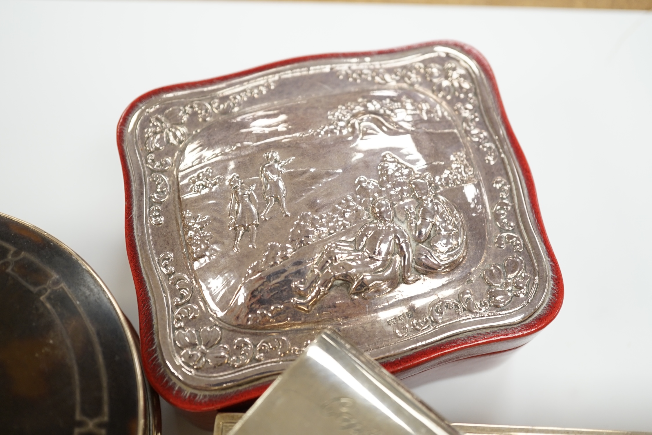 A George V silver and tortoiseshell mounted circular trinket box, Birmingham, 1923, 10cm, a silver cased travelling timepiece and two other silver mounted boxes including cigarette box.